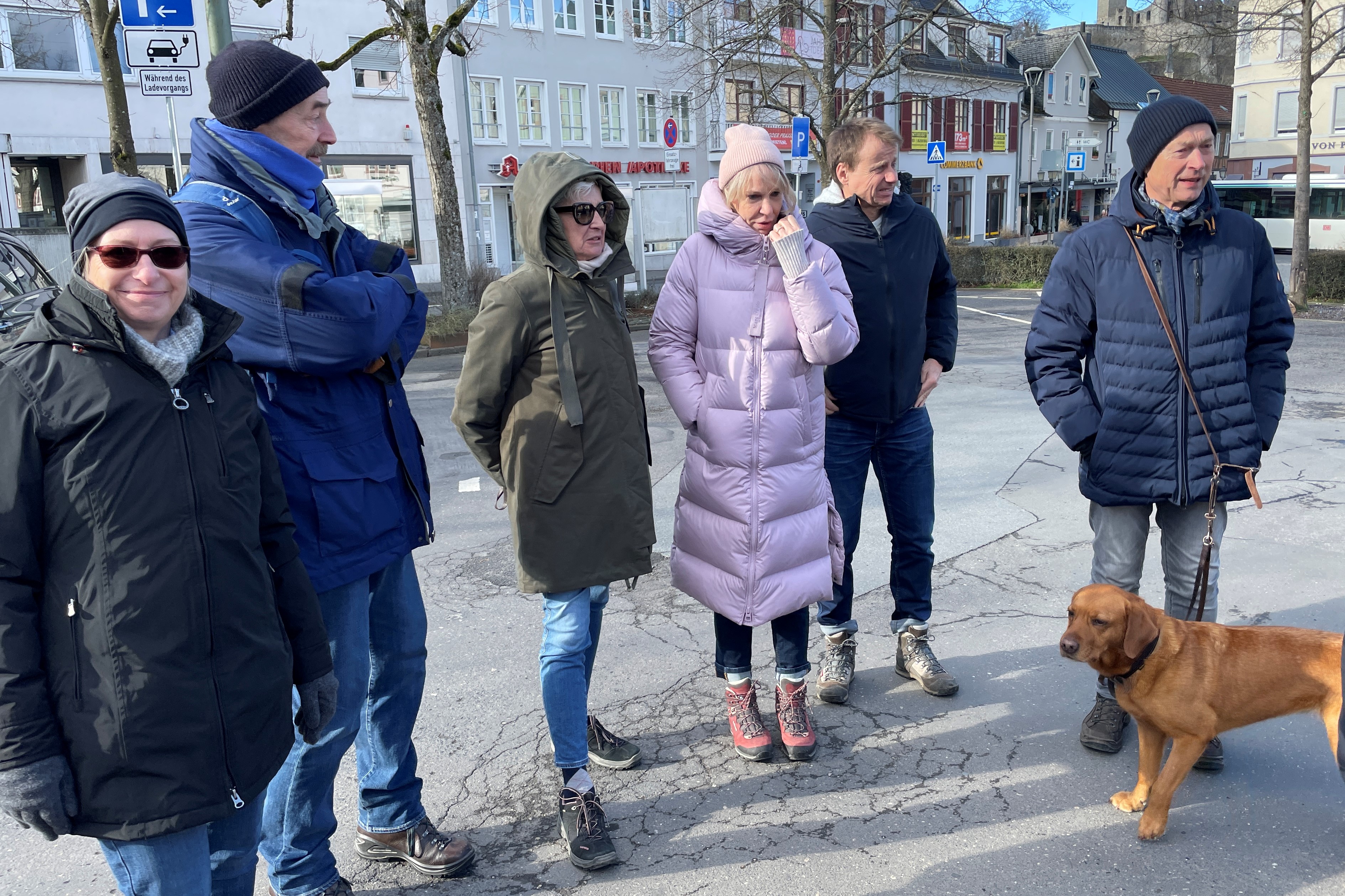 Mehrere Personen warten auf dem Parkplatz