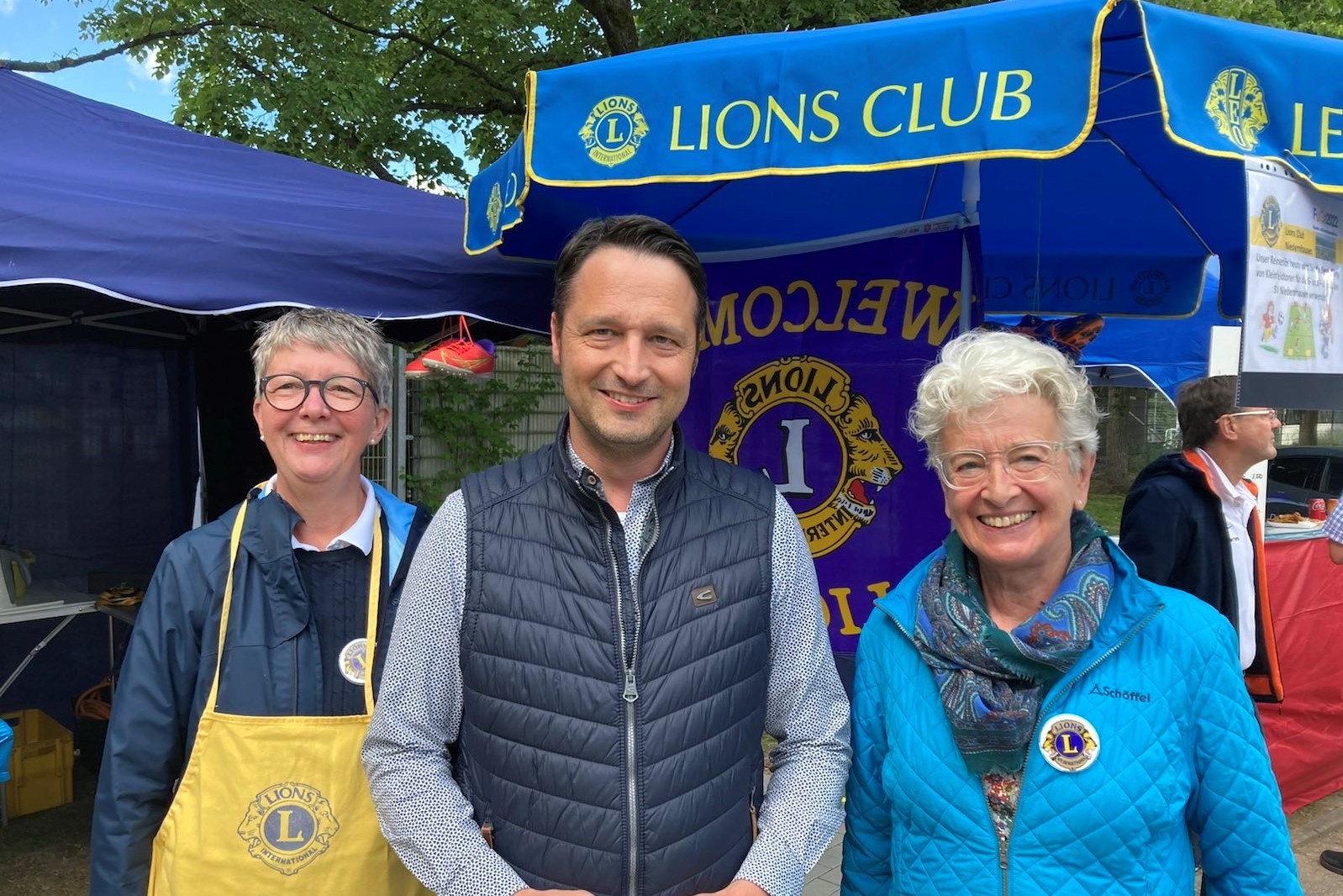 Bürgermeister Reimann, Barbara und Margret vor dem Stand