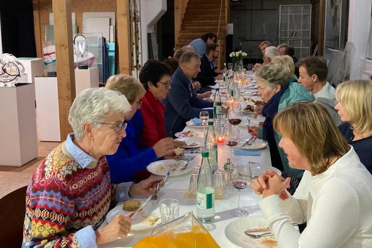 große Tafel mit den Besuchern, beim Essen und im Gespräch